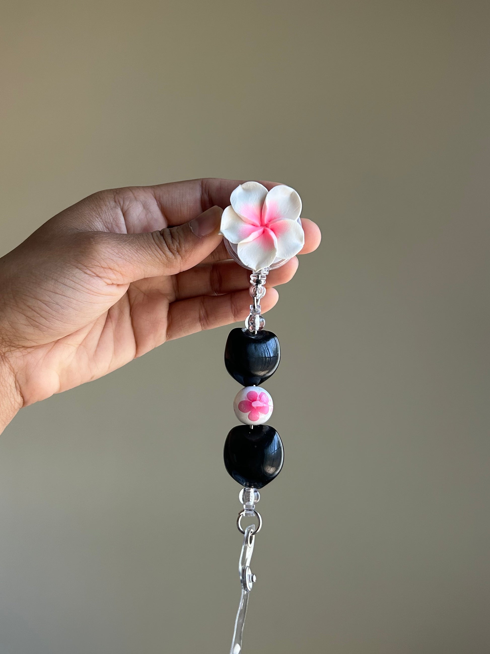 Plumeria floral kukui nut badge reel with retractable clip