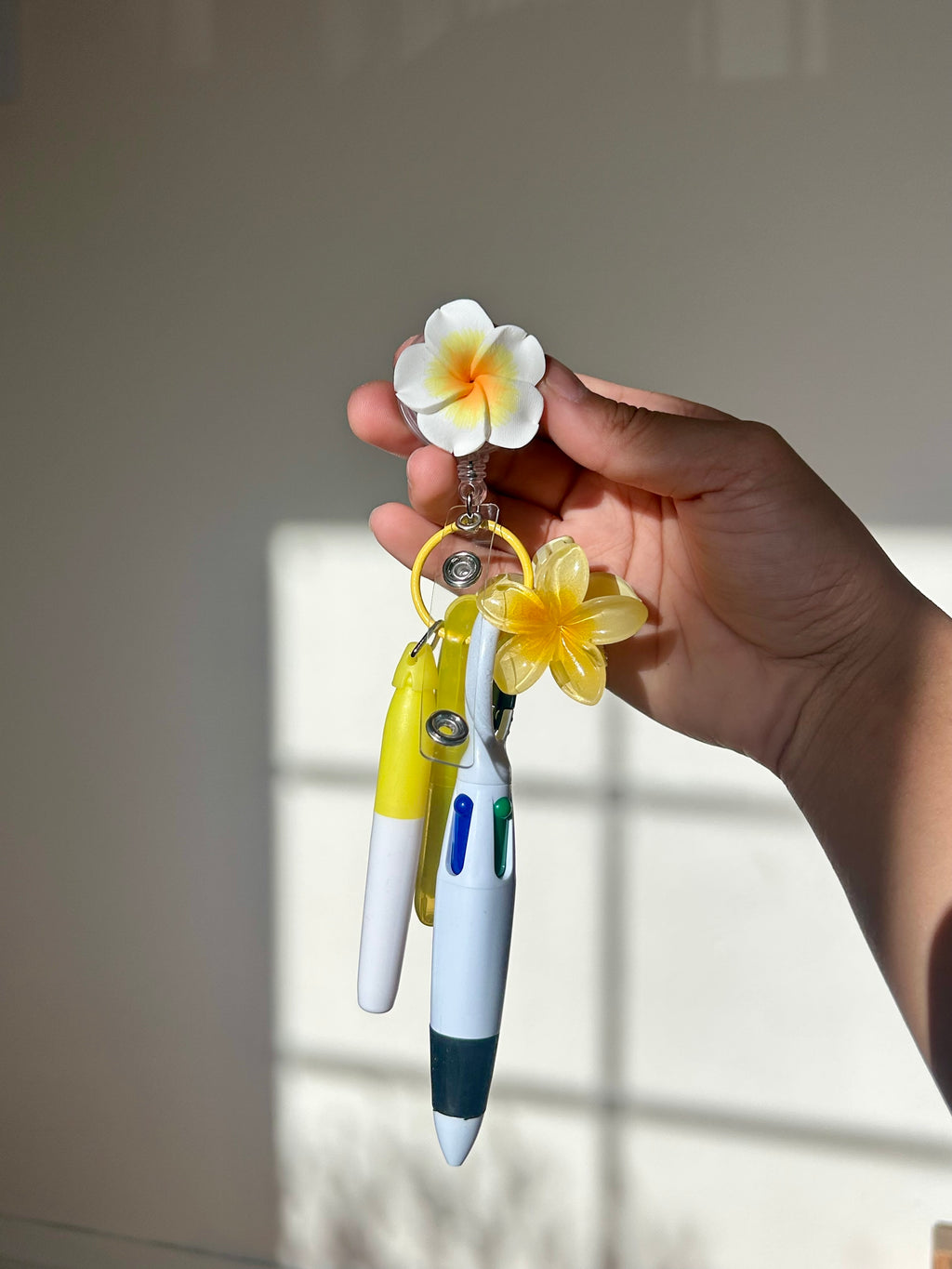 Yellow plumeria floral badge reel with retractable clip and pen set 