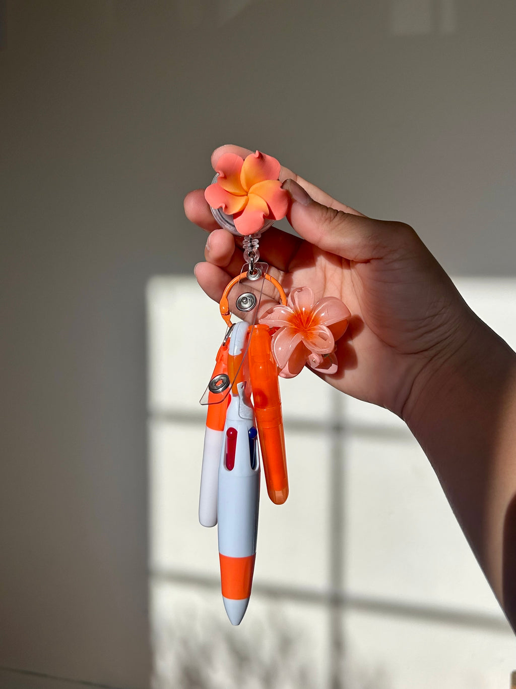 Orange plumeria floral badge reel with retractable clip and pen set 