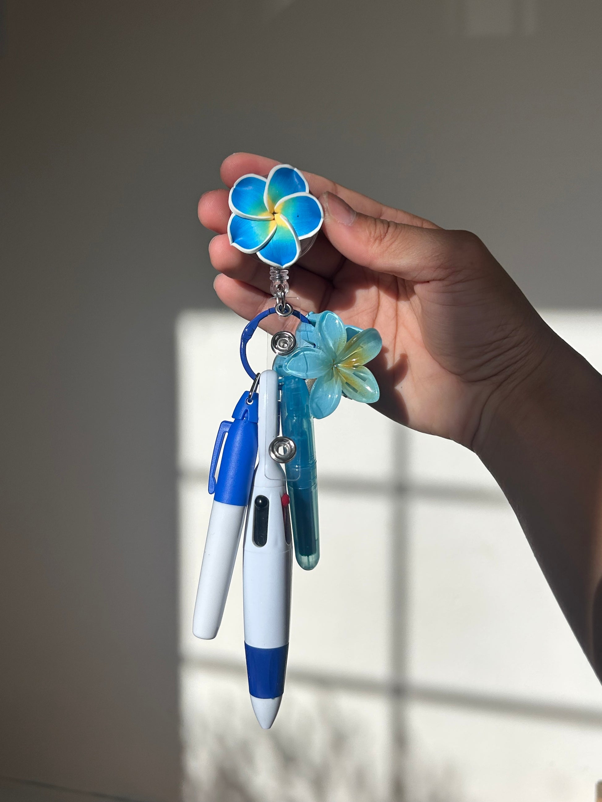 Blue plumeria floral badge reel with retractable clip and pen set 