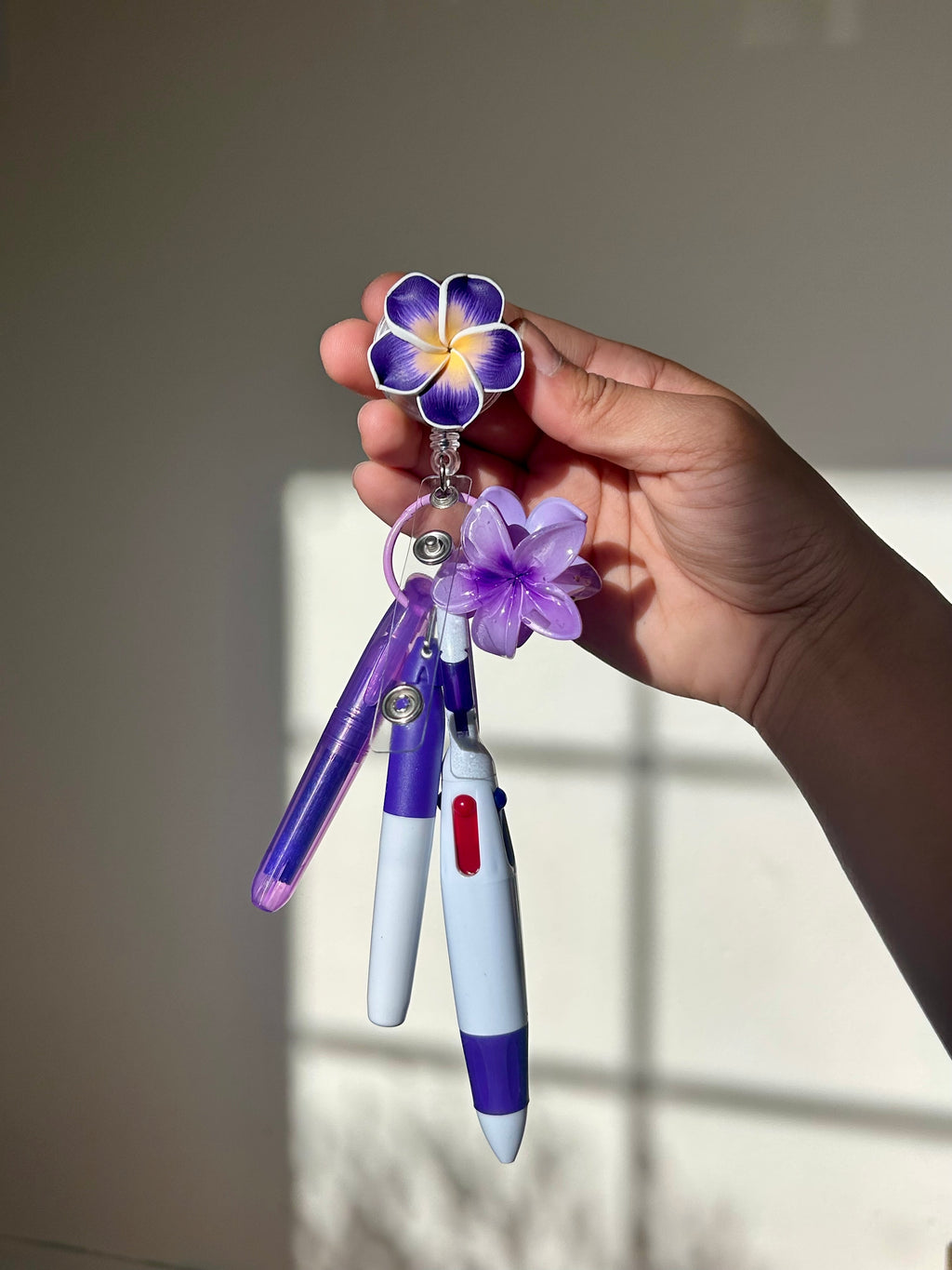 Purple plumeria floral badge reel with retractable clip and pen set 