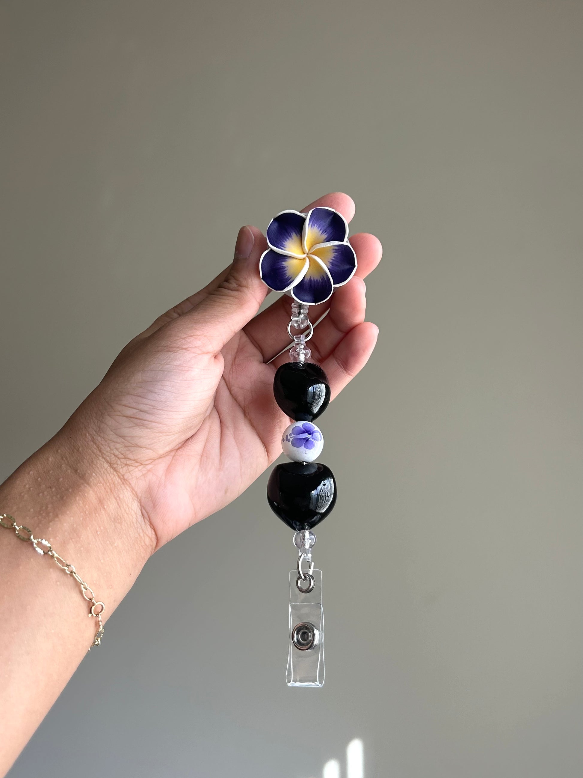 Purple plumeria kukui nut badge reel with retractable clip
