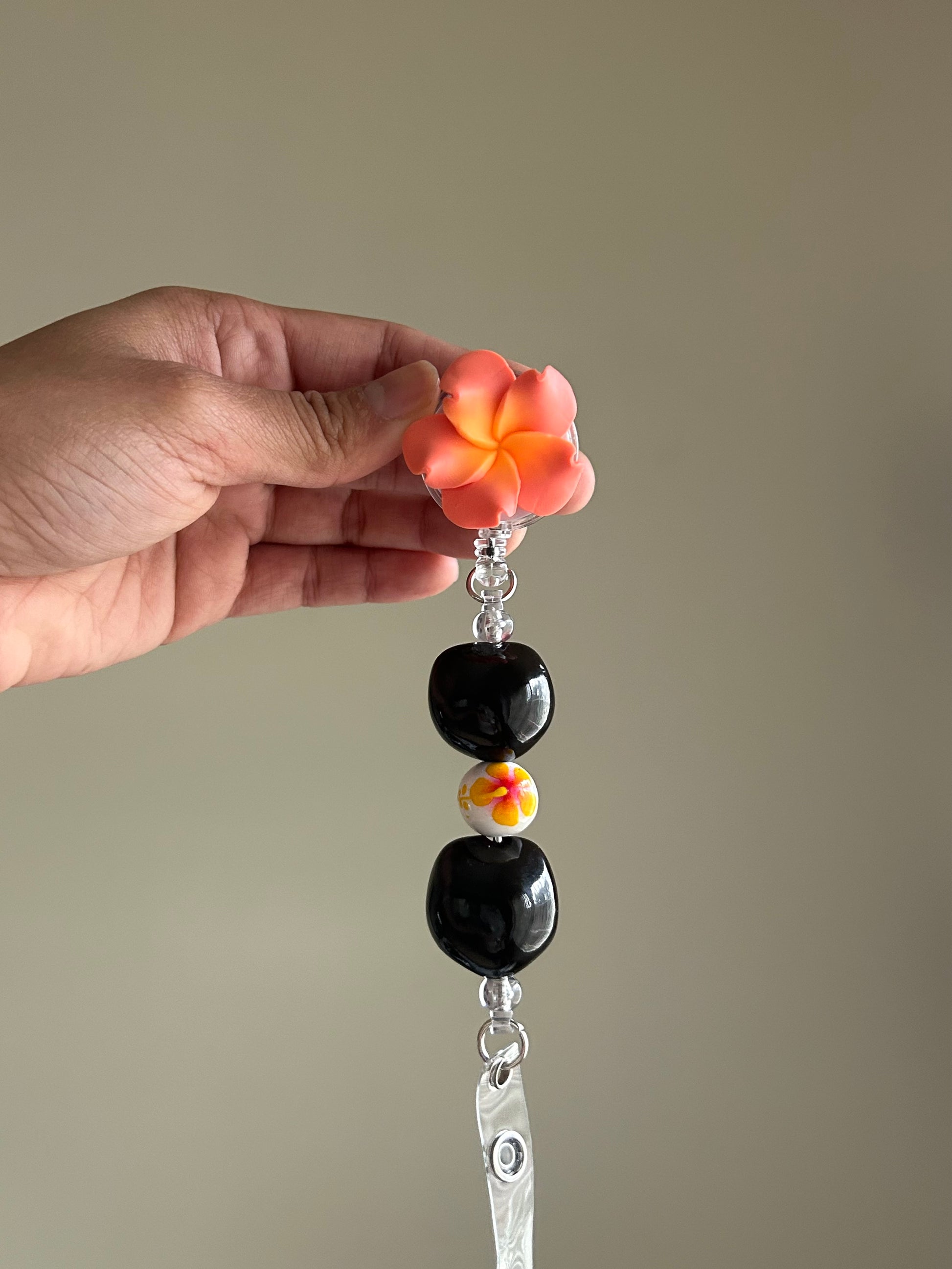 Coral plumeria floral kukui nut badge reel with retractable clip